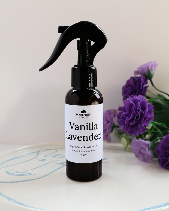 Luxury Vanilla Lavender home fragrance spray styled with purple carnations on a white designer tray, relaxing aromatherapy mist and linen spray by Harlequin Candles.