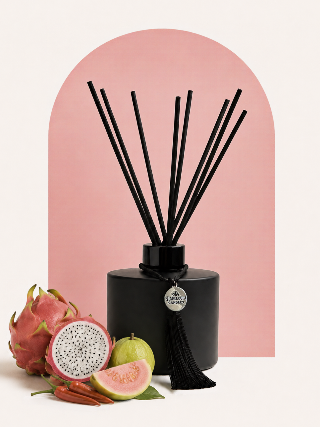 An Australian made Harlequin Candles reed diffuser with an exotic and spicy home scent called Fruit & Fire.The product is shown on a red background with dragonfruit, blackberries, and chili peppers and chipotle.