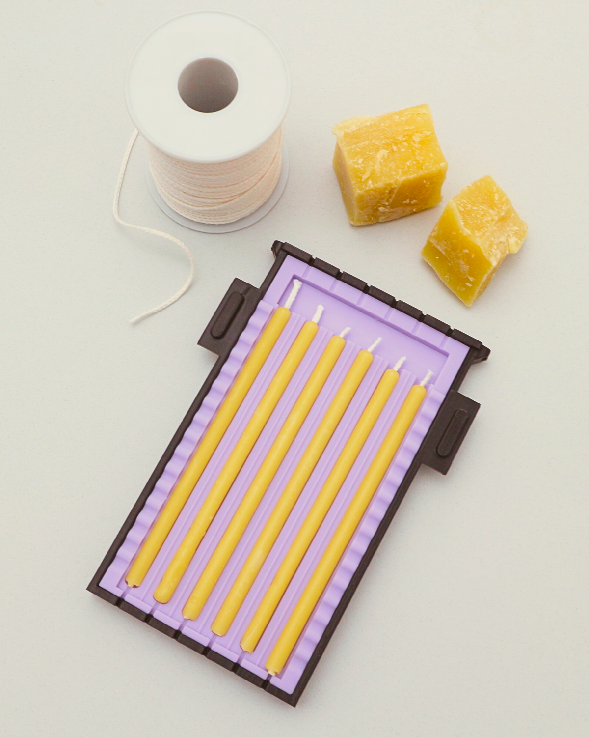 Yellow natural beeswax candles in candle mold with pure organic beeswax and cotton wick.