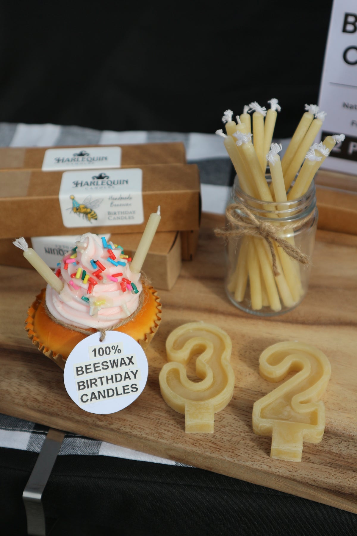 Handmade beeswax birthday candles by Harlequin Candles displayed at a Melbourne market, including number candles and traditional beeswax birthday candles.