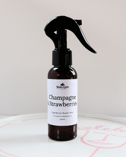 100ml amber bottle of Champagne and Strawberries signature room mist by Harlequin Candles, featuring a black trigger spray and minimalist white label.