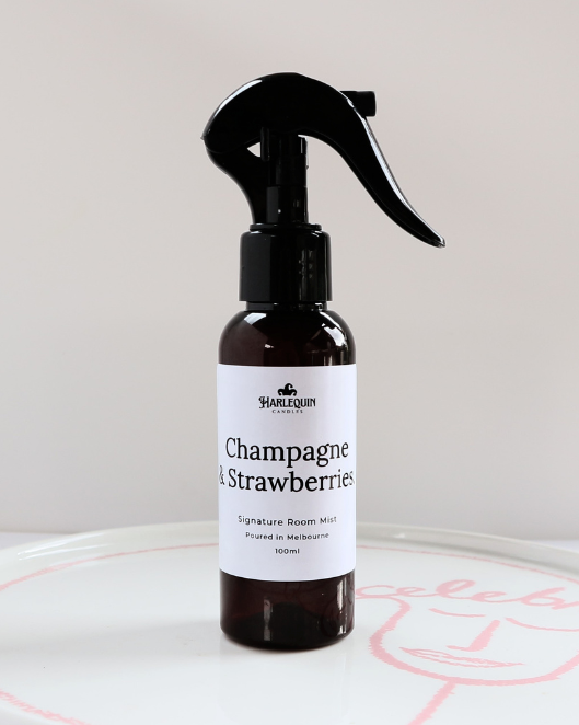 100ml amber bottle of Champagne and Strawberries signature room mist by Harlequin Candles, featuring a black trigger spray and minimalist white label.