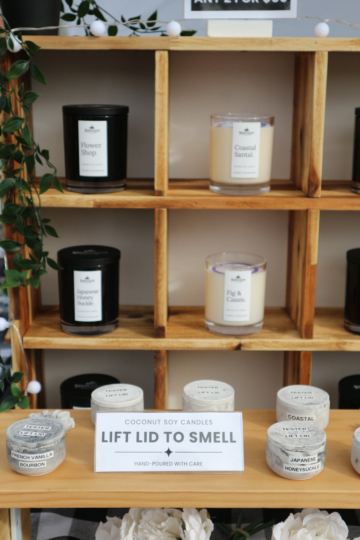 Handmade coconut soy candles by Harlequin Candles displayed at a Melbourne market.