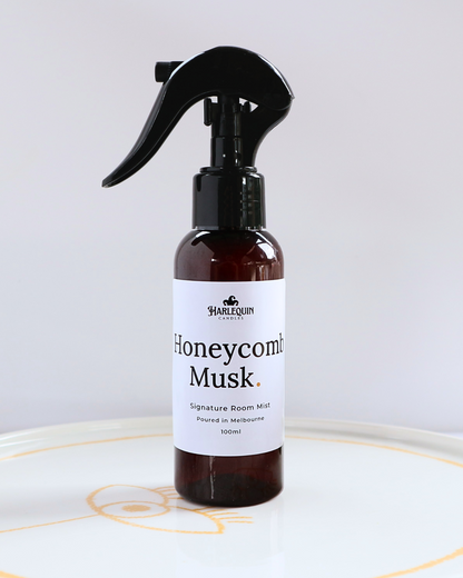 Harlequin Candles Honeycomb Musk 100ml signature room mist in a premium amber spray bottle on a minimalist white ceramic tray, hand-poured in Melbourne Australia.
