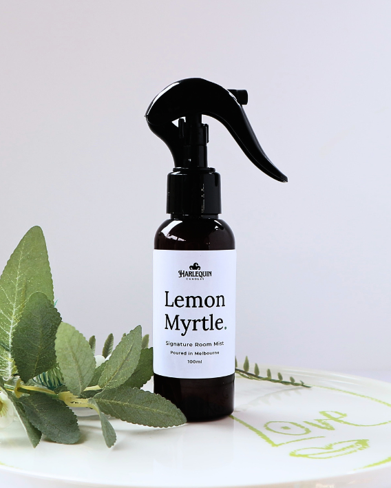 Luxury Lemon Myrtle home fragrance spray styled with fresh green eucalyptus leaves on a white designer tray, refreshing Australian native room deodorizer by Harlequin Candles.