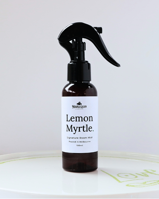 Harlequin Candles Lemon Myrtle 100ml signature room mist in a premium amber glass spray bottle on a minimalist white ceramic tray, hand-poured in Melbourne Australia.